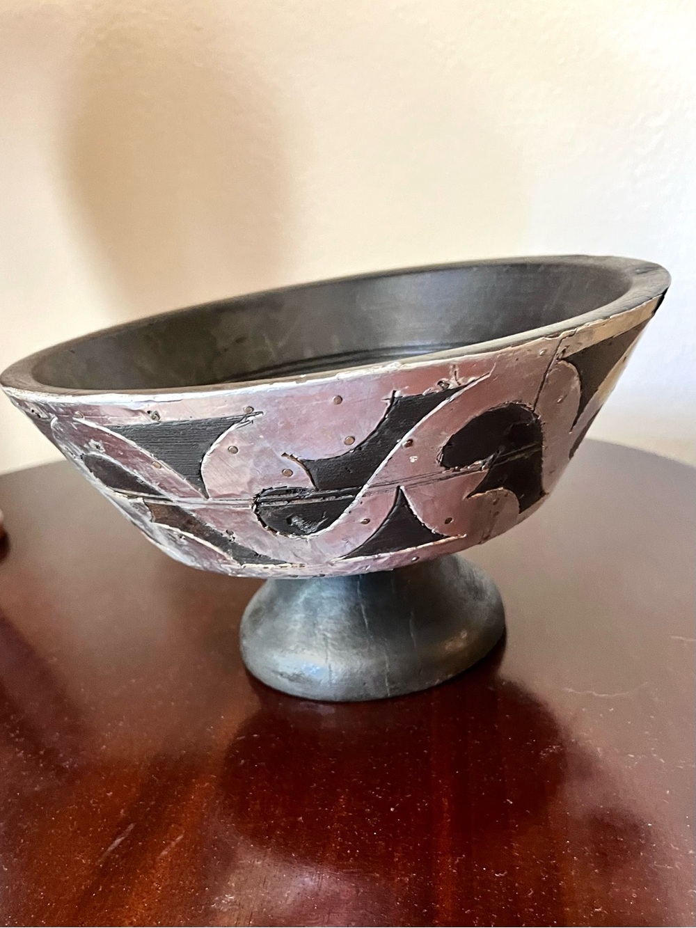 Vintage Indian Carved Wood Pedestal Bowl with nailed metal swirl design.
